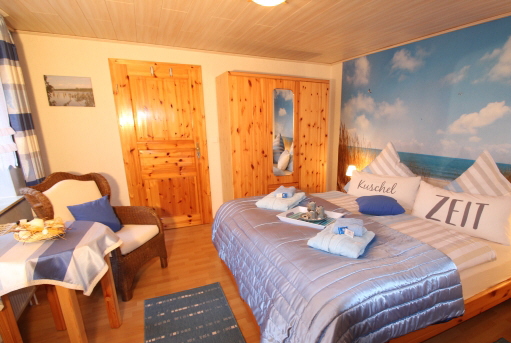 Schlafzimmer blau-wei der Ferienwohnung Lthje in Hochdonn in Dithmarschen am Nord-Ostsee-Kanal mit Doppelbett, Nachttischlampen, Nachttischen, Radiowecker, Herrendiener